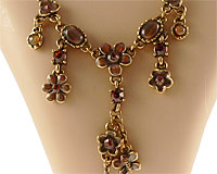 Se mere om ENVY halskæde i messingfarve med blomster i brunlige sten i web-butikken