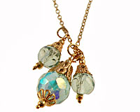Se mere om Lang guldfarvet halskæde med glasperler i lyseblå farve i web-butikken